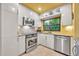 Bright eat-in kitchen with stainless steel appliances, white cabinets, and a window overlooking foliage at 535 N Interlachen Ave # 107, Winter Park, FL 32789