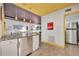 Bright eat-in kitchen with stainless steel appliances, white cabinets, and a window overlooking foliage at 535 N Interlachen Ave # 107, Winter Park, FL 32789