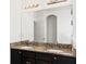 Bathroom with double sinks, granite counters, dark cabinets and large mirror at 625 Silverthorn Pl, Groveland, FL 34736