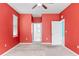Large bedroom with neutral carpet, bright red walls, and white trim at 625 Silverthorn Pl, Groveland, FL 34736