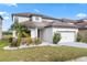 Home exterior boasts manicured lawn, stone accents, a two-car garage, and a driveway at 625 Silverthorn Pl, Groveland, FL 34736