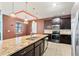 A large kitchen with an island, dark cabinets, granite countertops and stainless steel appliances at 625 Silverthorn Pl, Groveland, FL 34736