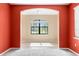 A view into a room with red accent walls and tan walls, tile flooring and a carpeted room at the foreground at 625 Silverthorn Pl, Groveland, FL 34736