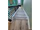 Staircase features wood stairs, a black iron railing, and leads to a naturally lit landing at 625 Silverthorn Pl, Groveland, FL 34736