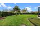 Well-manicured backyard with lush green grass and mature landscaping at 7135 Ticklegrass St, Winter Garden, FL 34787