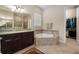 Well-appointed bathroom with double vanity, soaking tub, and walk-in closet provides comfort and luxury at 7135 Ticklegrass St, Winter Garden, FL 34787