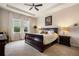 Bright bedroom featuring a tray ceiling, a ceiling fan and large windows with bright white curtains at 7135 Ticklegrass St, Winter Garden, FL 34787