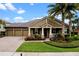 Charming home showcasing a well-maintained front yard, a three-car garage, and a welcoming front porch at 7135 Ticklegrass St, Winter Garden, FL 34787