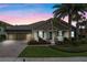 Charming home exterior with a well-manicured lawn, palm tree, and inviting front porch at 7135 Ticklegrass St, Winter Garden, FL 34787