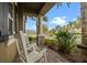 Inviting front porch with rocking chairs, stone accents, and tropical landscaping at 7135 Ticklegrass St, Winter Garden, FL 34787