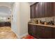 Hallway featuring built-in bar with dark wood cabinets and decorative counter for entertaining at 7135 Ticklegrass St, Winter Garden, FL 34787