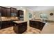 Beautiful kitchen featuring dark wood cabinets, an island, and modern appliances at 7135 Ticklegrass St, Winter Garden, FL 34787