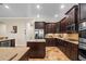 Gourmet kitchen with stainless steel appliances, dark wood cabinets, and granite countertops at 7135 Ticklegrass St, Winter Garden, FL 34787