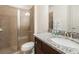 Bathroom with a glass door shower and a single granite countertop sink with dark brown wooden cabinets at 7568 Marker Ave, Kissimmee, FL 34747