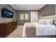 Bedroom featuring neutral walls, white linens, a wooden dresser, and a mounted television at 7568 Marker Ave, Kissimmee, FL 34747