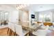 Bright dining room with a distinctive glass table and contemporary decor that seamlessly blends with adjacent living area at 7568 Marker Ave, Kissimmee, FL 34747