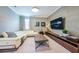 Spacious living room featuring modern decor, a large sectional sofa, and stylish entertainment center at 7568 Marker Ave, Kissimmee, FL 34747