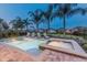 Outdoor pool area with lounge chairs, a jacuzzi, palm trees, and a serene atmosphere for relaxation at 7568 Marker Ave, Kissimmee, FL 34747