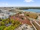 An aerial view of a building with red roofs, surrounding buildings, highways, and a waterfront view at 911 N Orange Ave # 104, Orlando, FL 32801