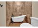 This bathroom is equipped with a luxurious clawfoot bathtub with vintage fixtures and beautiful marble-tiled walls at 911 N Orange Ave # 104, Orlando, FL 32801