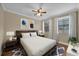 Cozy bedroom with a dark wood bed frame, ceiling fan, neutral walls, and natural light from two windows at 911 N Orange Ave # 104, Orlando, FL 32801