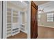 Walk-in closet with custom shelving, wooden barn door and a view of the bedroom at 911 N Orange Ave # 104, Orlando, FL 32801