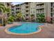 A sparkling community pool surrounded by tropical landscaping and a beautiful apartment complex at 911 N Orange Ave # 104, Orlando, FL 32801