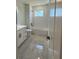 Bright bathroom with a tub, shower, window, white subway tile and a white vanity with dark fixtures at 917 Swallow St, Deltona, FL 32725