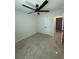 A bedroom with light colored tile, a ceiling fan, white trim, and a white door with dark hardware at 917 Swallow St, Deltona, FL 32725