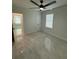 Bright bedroom with grey tile flooring, a ceiling fan and a window for natural light at 917 Swallow St, Deltona, FL 32725
