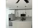 Modern kitchen features white cabinets, stainless steel appliances, pendant lighting, and a center island with a sink at 917 Swallow St, Deltona, FL 32725