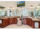 A bathroom features granite countertops, dual sinks, and multiple mirrors, illuminated by decorative lighting at 10411 Hart Branch Cir, Orlando, FL 32832