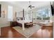 A spacious bedroom featuring a four-poster bed, a ceiling fan, and large windows that bring in natural light at 10411 Hart Branch Cir, Orlando, FL 32832