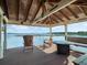 Outdoor seating area on a covered wooden boat dock with comfortable chairs, tables and views of the tranquil lake at 10411 Hart Branch Cir, Orlando, FL 32832