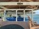 A covered boat dock with lift, featuring a stylish blue boat, wooden flooring and picturesque lake views at 10411 Hart Branch Cir, Orlando, FL 32832