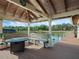 Covered boat dock with bench seating, side table, and views of the water and the trees along the shore at 10411 Hart Branch Cir, Orlando, FL 32832