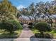 Beautiful home with a circular driveway, pillars at the front door, and lush landscaping beneath a gorgeous tree canopy at 10411 Hart Branch Cir, Orlando, FL 32832
