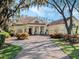 Beautiful home featuring a circular driveway, pillars at the front door, and a landscaped front yard with blue skies at 10411 Hart Branch Cir, Orlando, FL 32832