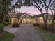 Stunning home featuring a circular driveway and a meticulously landscaped front yard with mature trees and lush greenery at 10411 Hart Branch Cir, Orlando, FL 32832