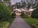 An expansive home with a circular driveway and lush landscaping is framed by beautiful, mature trees at 10411 Hart Branch Cir, Orlando, FL 32832