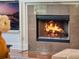 Close up view of a stone fireplace with flames and mounted television at 10411 Hart Branch Cir, Orlando, FL 32832