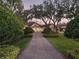 Charming home featuring a brick driveway, manicured landscaping, and mature trees draped with Spanish moss at 10411 Hart Branch Cir, Orlando, FL 32832