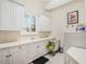 Bright laundry room features lots of cabinets, a sink, and space for a washer and dryer at 10411 Hart Branch Cir, Orlando, FL 32832
