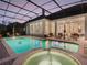 Screened-in pool and spa with outdoor seating under a covered patio for relaxing and entertaining at 10411 Hart Branch Cir, Orlando, FL 32832