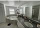 Bathroom featuring soaking tub, double sinks with gray countertops, and a glass enclosed shower at 11137 Lore Way, Orlando, FL 32832