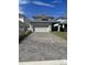 Detached two-car garage showcasing a paved driveway, solar panels and a neatly kept backyard at 11137 Lore Way, Orlando, FL 32832