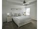 Bright main bedroom featuring a ceiling fan, two framed art pieces, and matching nightstands with lamps at 11137 Lore Way, Orlando, FL 32832