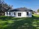 Rear exterior of a single-story home with a large yard and dark-colored roof at 12793 Sw 43Rd Cir, Ocala, FL 34473