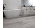 Freestanding bathtub in a modern bathroom with gray-toned wood floors and a double sink vanity at 12793 Sw 43Rd Cir, Ocala, FL 34473