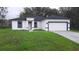 Attractive new home with a crisp white exterior, black trim, and a well-manicured lawn at 12793 Sw 43Rd Cir, Ocala, FL 34473